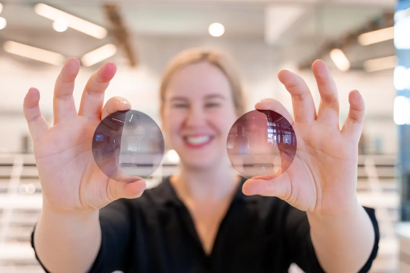 An E Eye Place team member holding up two spectacle lenses