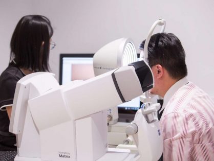 Person undergoing a dry eye diagnosis test, with a specialist examining their eyes using diagnostic equipment