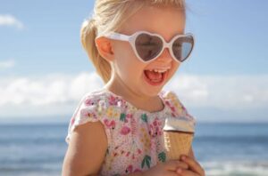 Toddler wearing sunglasses at the beach.