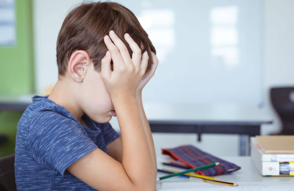 Young student rubbing his eyes.