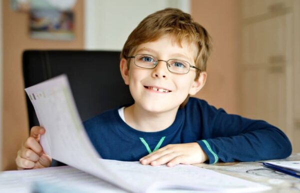 Young boy wearing glasses doing school work.