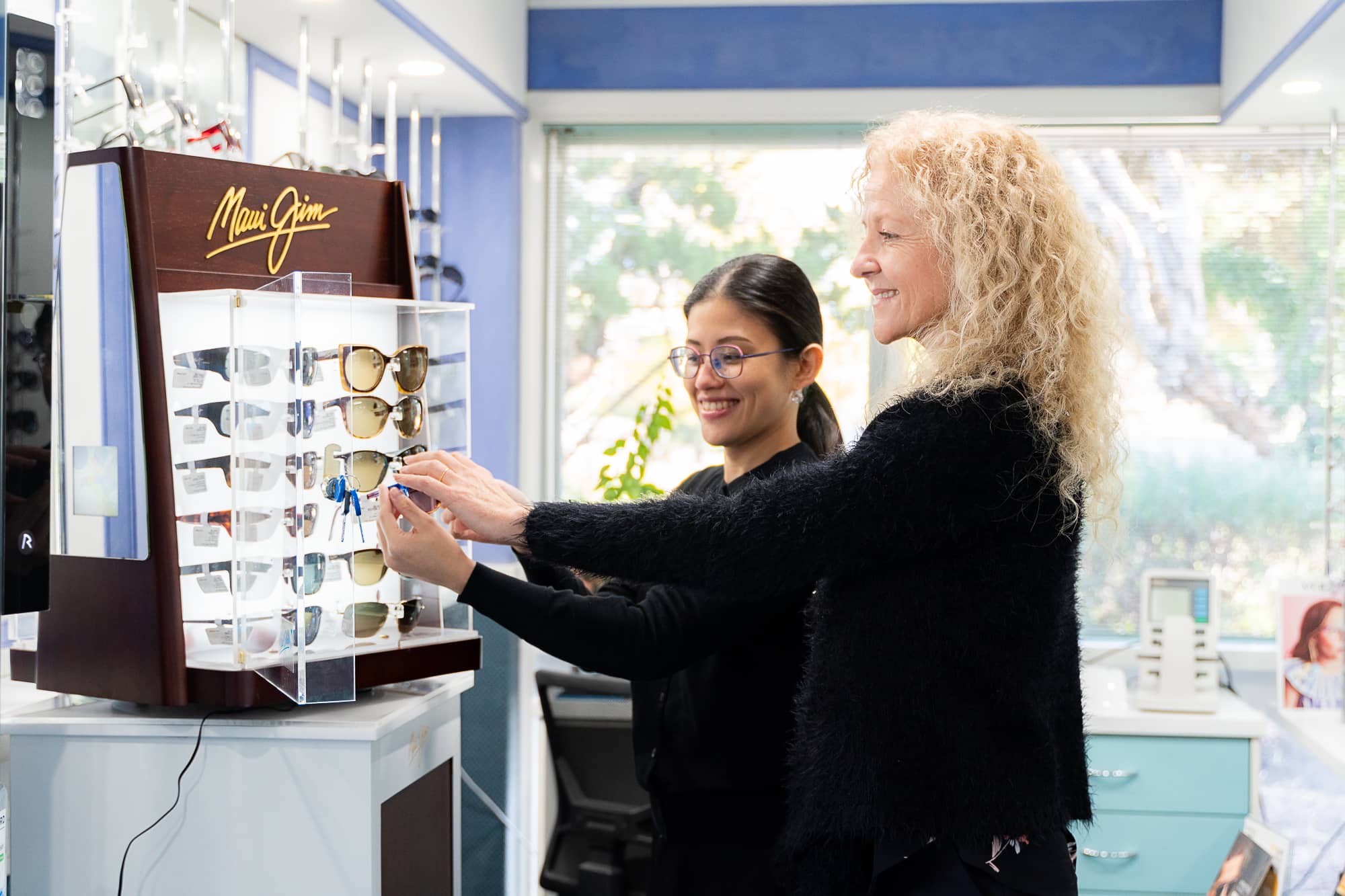 customer and optometrist selecting glasses frames